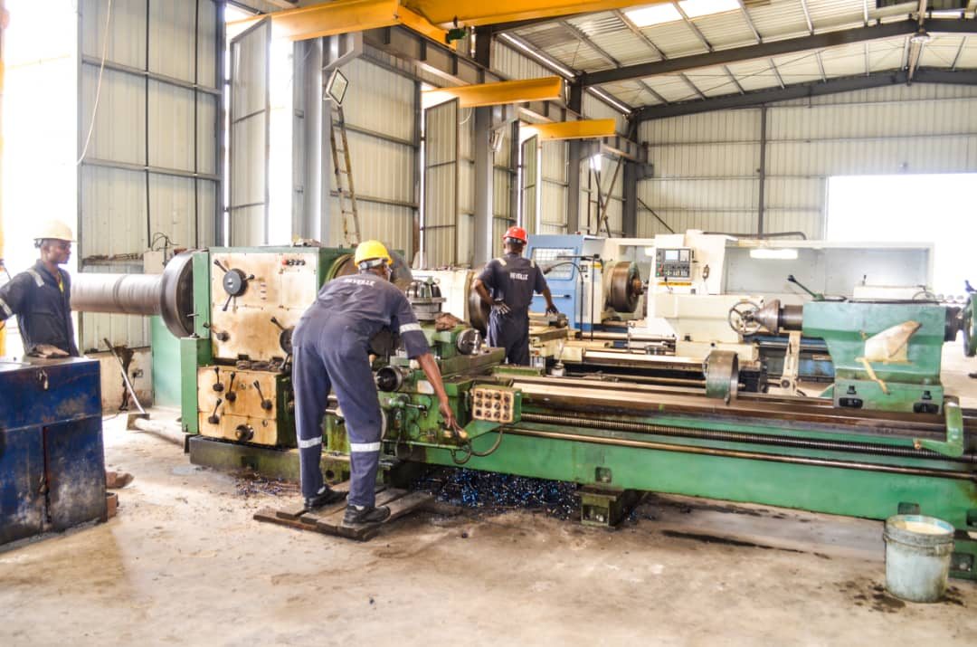 Reveille technicians operating a heavy-duty threading lathe